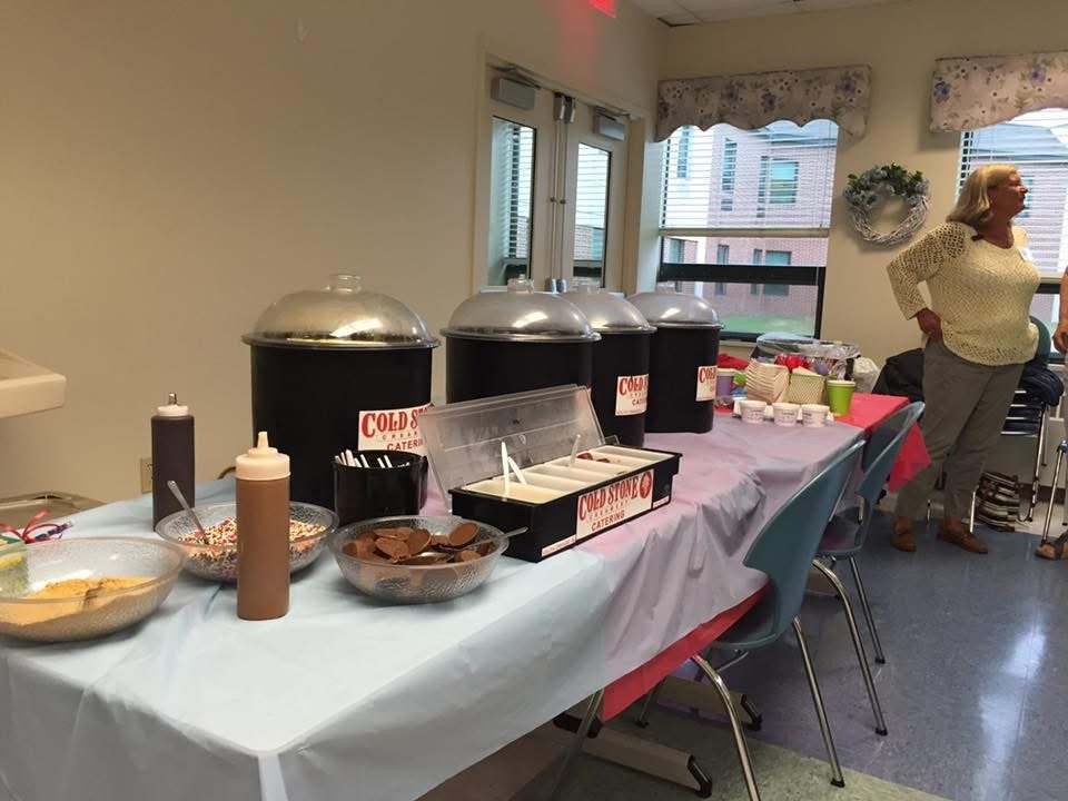 A Cold Stone sundae bar set up indoors with toppings ready to serve