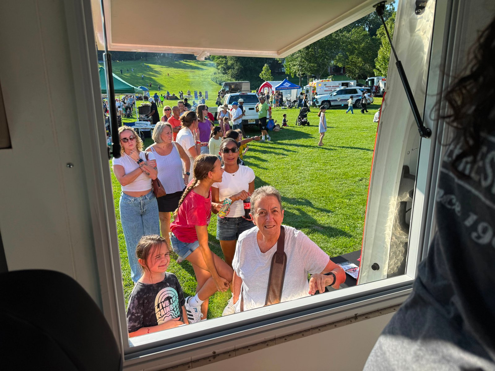 A crowd gathered at the Cold Stone ice cream truck window